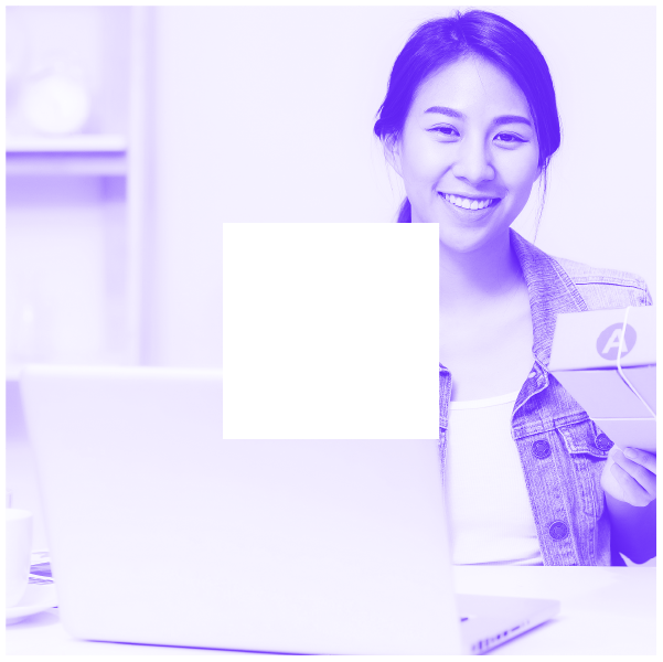 Woman smiling behind laptop and holding small package